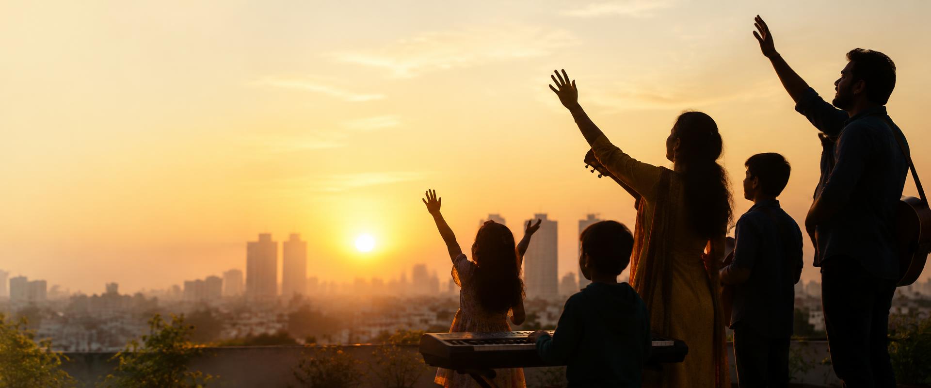 A family worshipping with instruments at sunrise